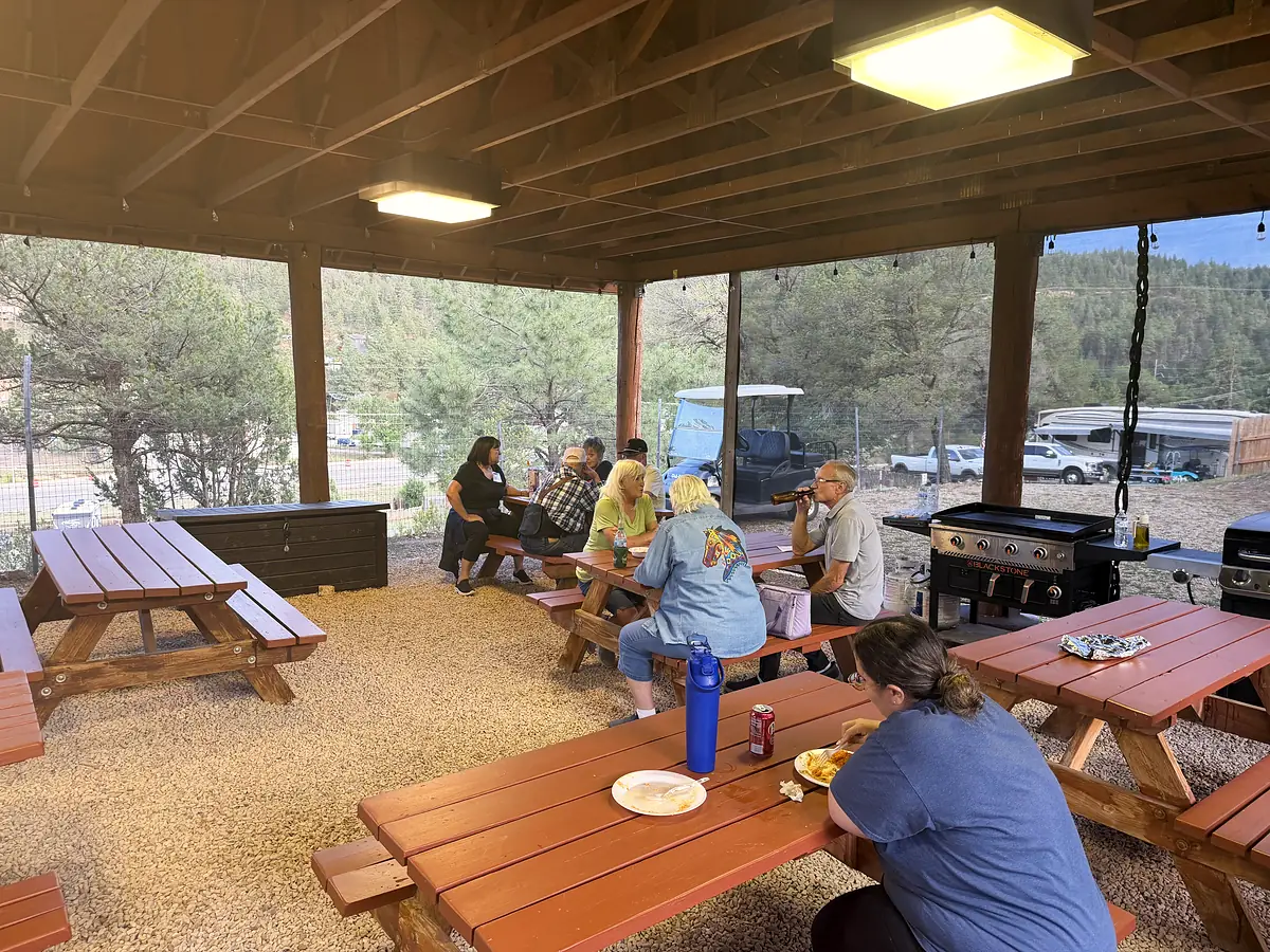 Guests sharing a meal at the picnic tables under the pavilion