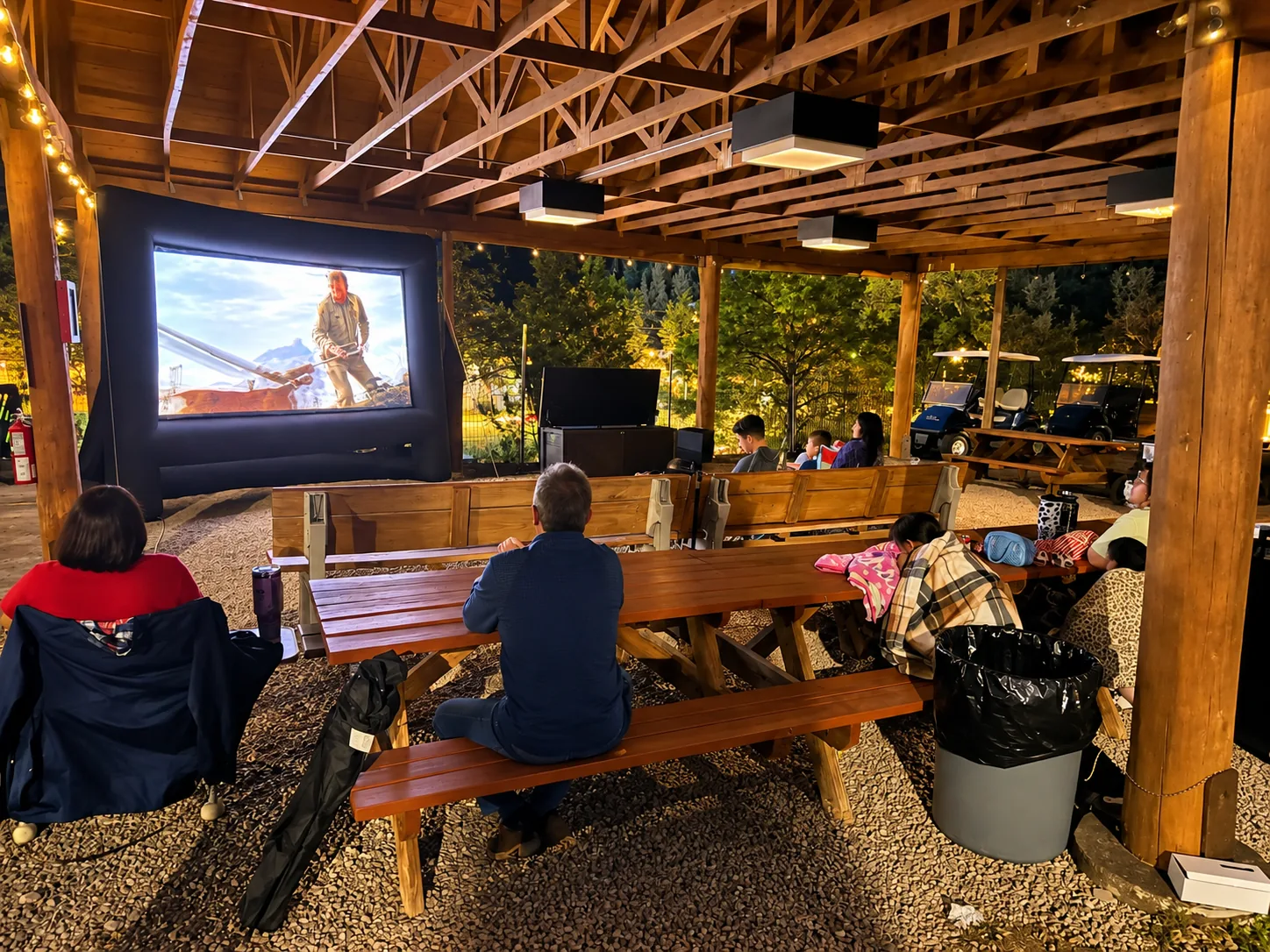 Guests watching a film on the big screen under the pavilion